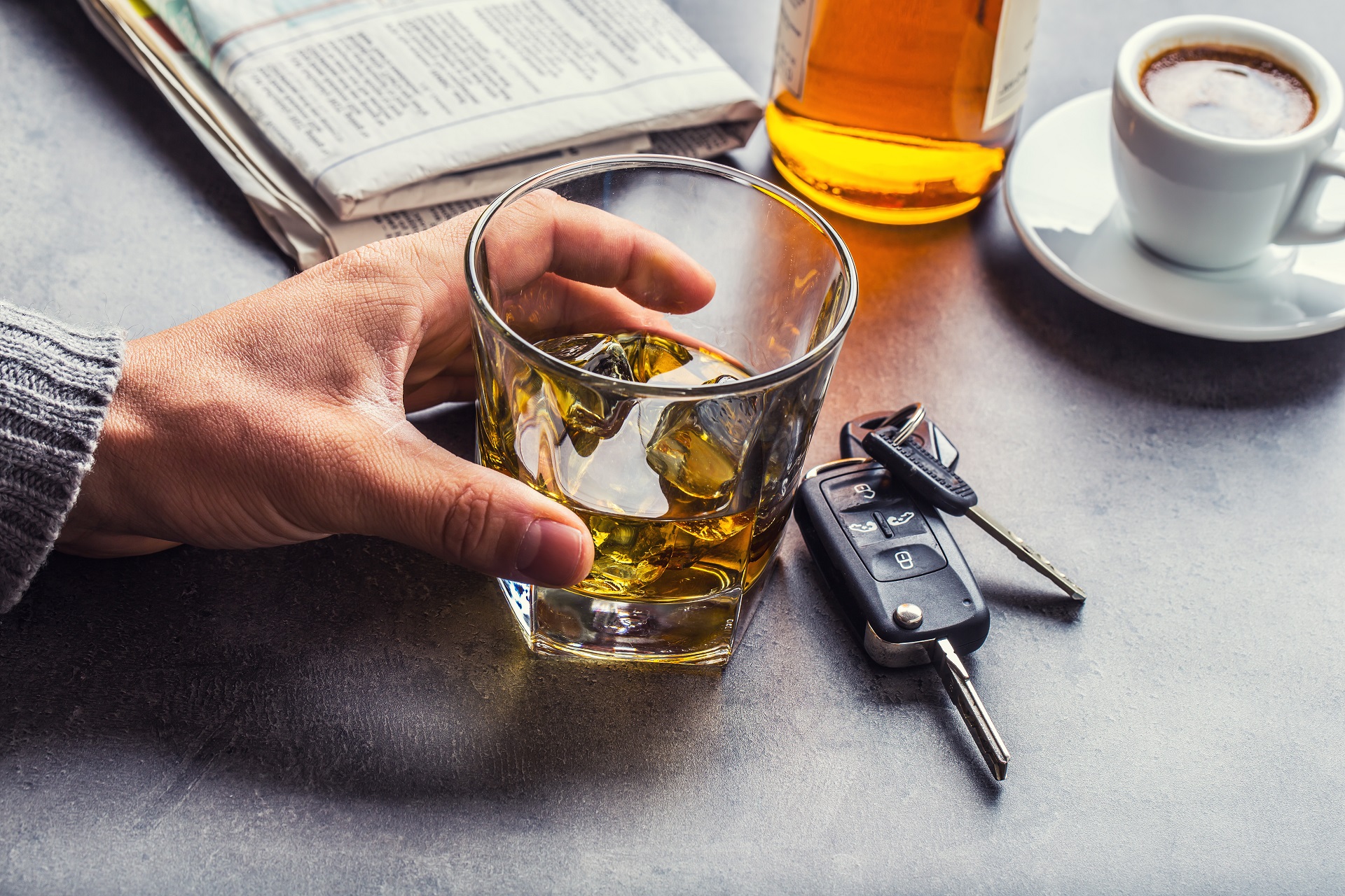 A Man Holds A Glass Of Alcohol Beside A Key | Law Offices Of David M. Wallin
