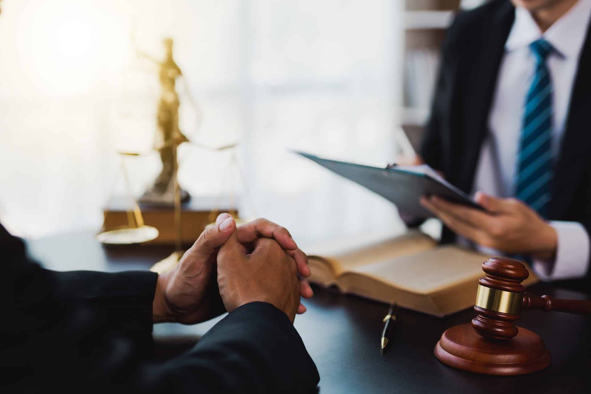A Man Sitting At A Table In Front Of A Judge | Law Offices Of David M. Wallin