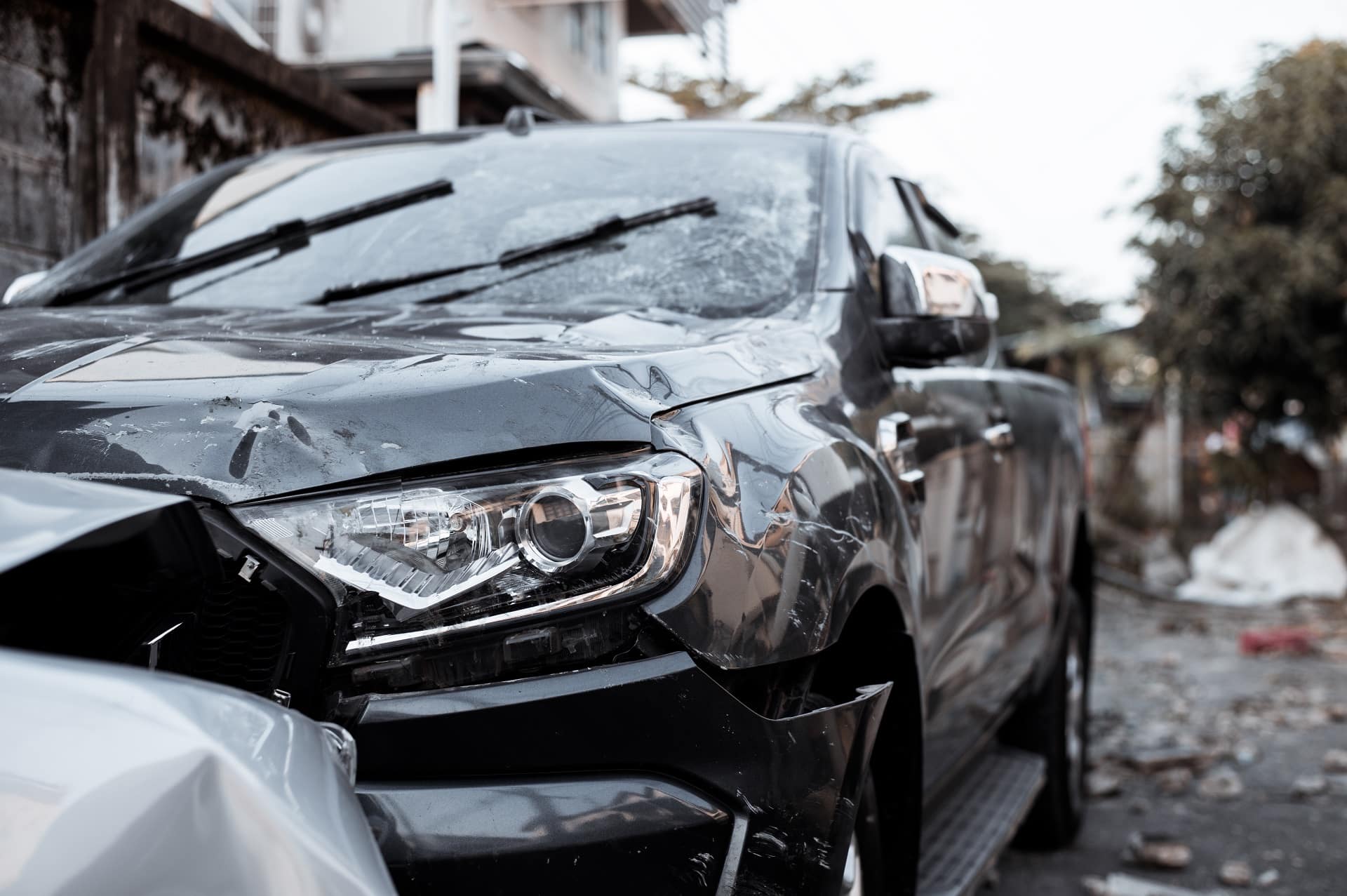 A Damaged Car Parked In Front Of A Building | Law Offices Of David M. Wallin
